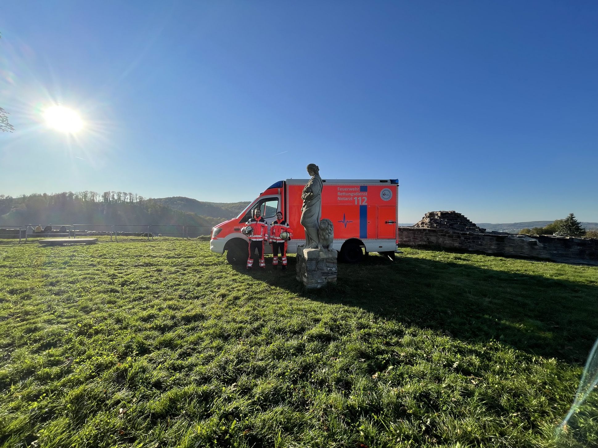 Zwei Rettungsdienstmitarbeiter vor der Schlossruine im Hintergrund ein Rettungswagen