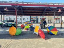 Auf dem Neheimer Marktplatz sind farbige Regenschirme und der Aktionsstand der "Oma gegen rechts" zu sehen