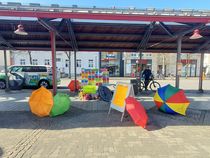 Auf dem Neheimer Marktplatz sind farbige Regenschirme und der Aktionsstand der "Oma gegen rechts" zu sehen