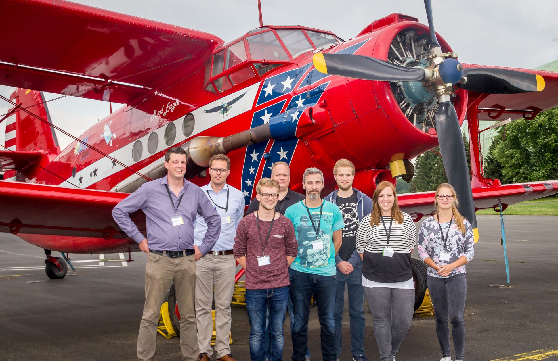 Gruppenbild von Rettungsdienstmitarbeitern vor einem roten Flugzeug